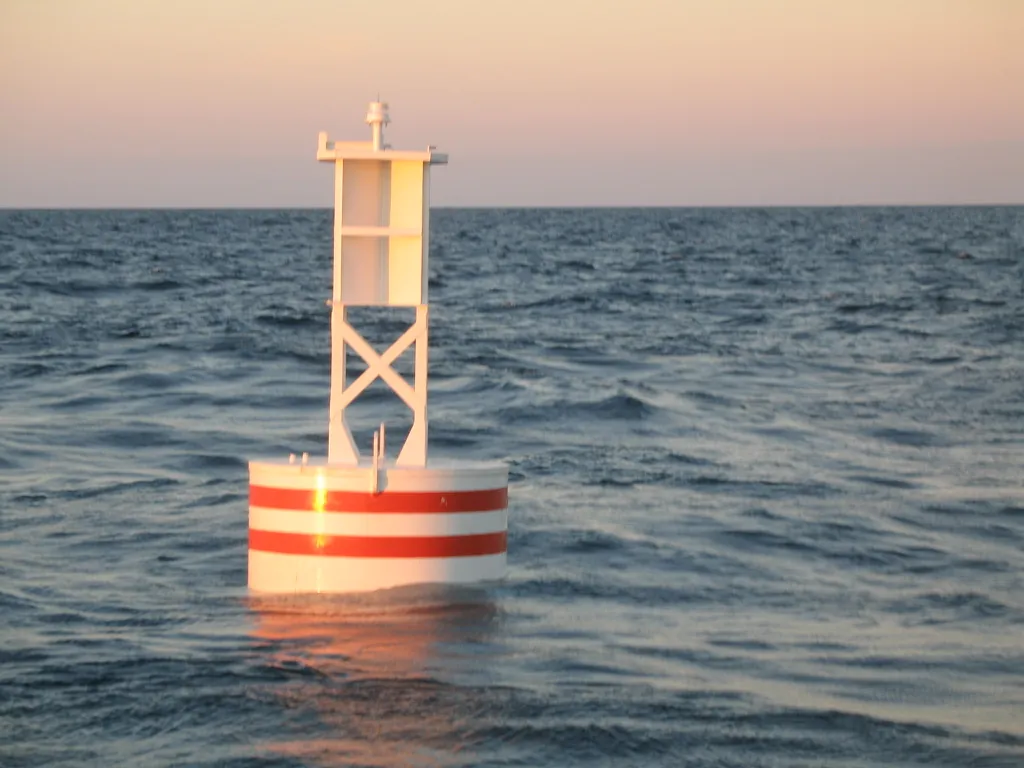 BL 620 6 ft x 20 ft white steel buoy with red bands and LED lantern on station offshore